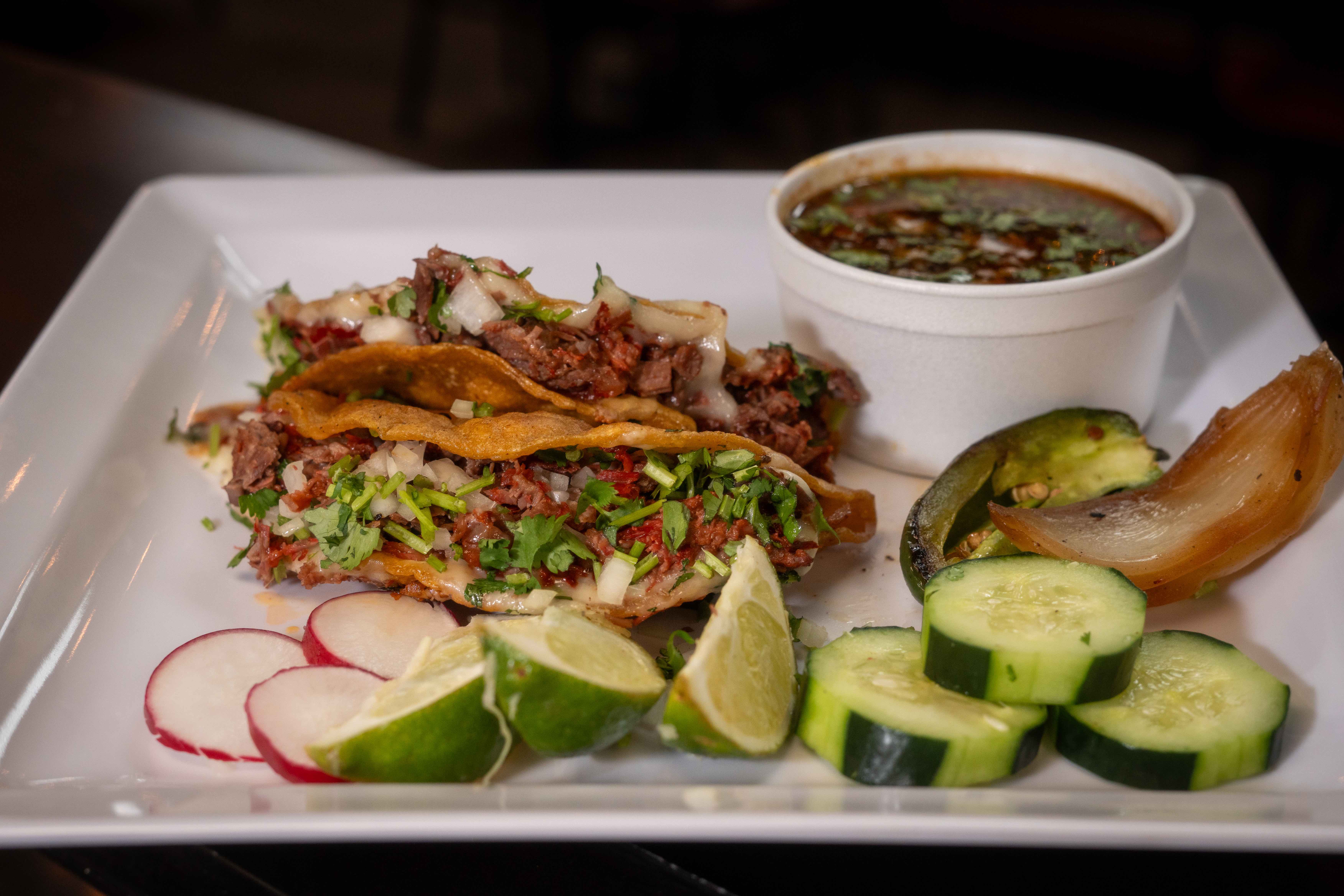 Birria Tacos plated with consommé